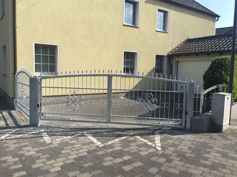 Ein gelbes Haus mit einem Schiebetor davor