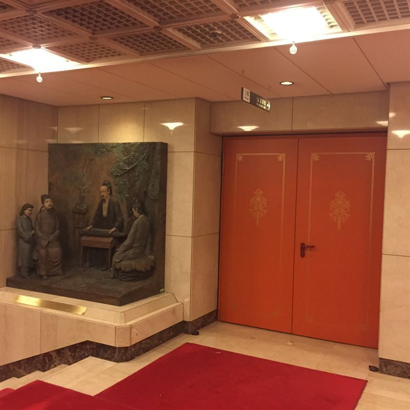 Ein Raum mit einer orangefarbenen Tür und einem Gemälde an der Wand