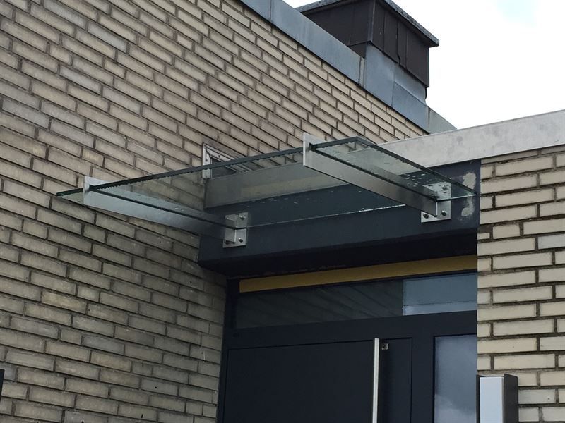 Ein Backsteingebäude mit einem Glasdach über der Tür.