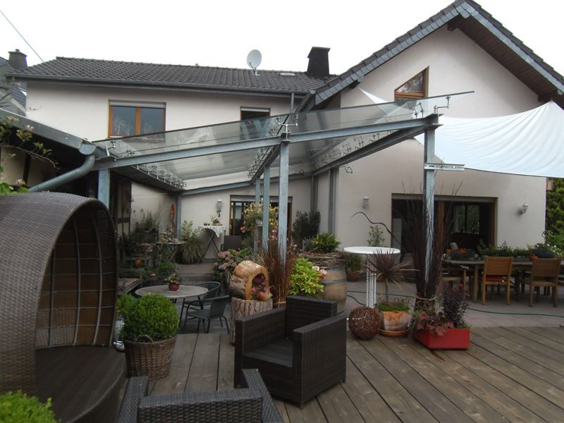 Ein großes Haus mit einer Terrasse mit Stühlen und Tischen