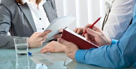 Un grupo de personas está sentado en una mesa teniendo una reunión.