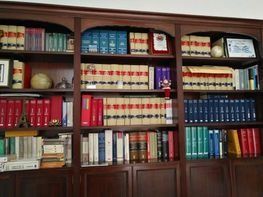 Una estantería llena de muchos libros y un globo terráqueo.