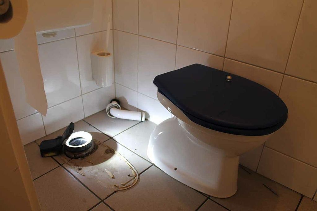 Toilette mit separatem Sanitärbereich auf gefliestem Boden.