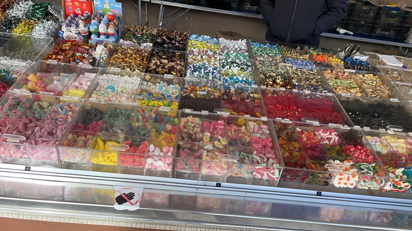 Una vitrina llena de diversos dulces de colores en un mercado.