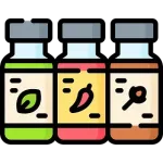 Tres frascos de especias: verde con una hoja, rojo con un chile y marrón con una especia, etiquetados.