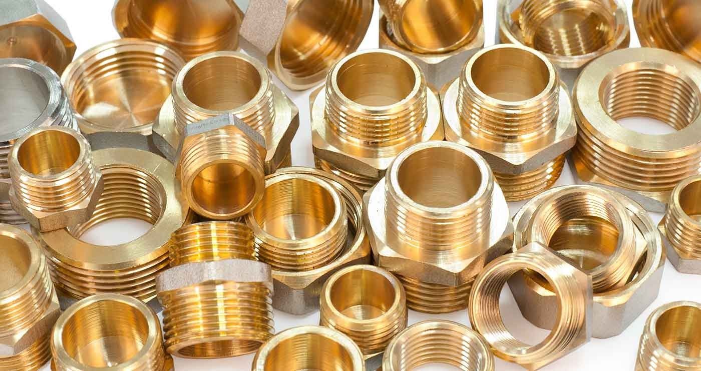 Hay muchos tipos diferentes de accesorios de latón sobre un fondo blanco.