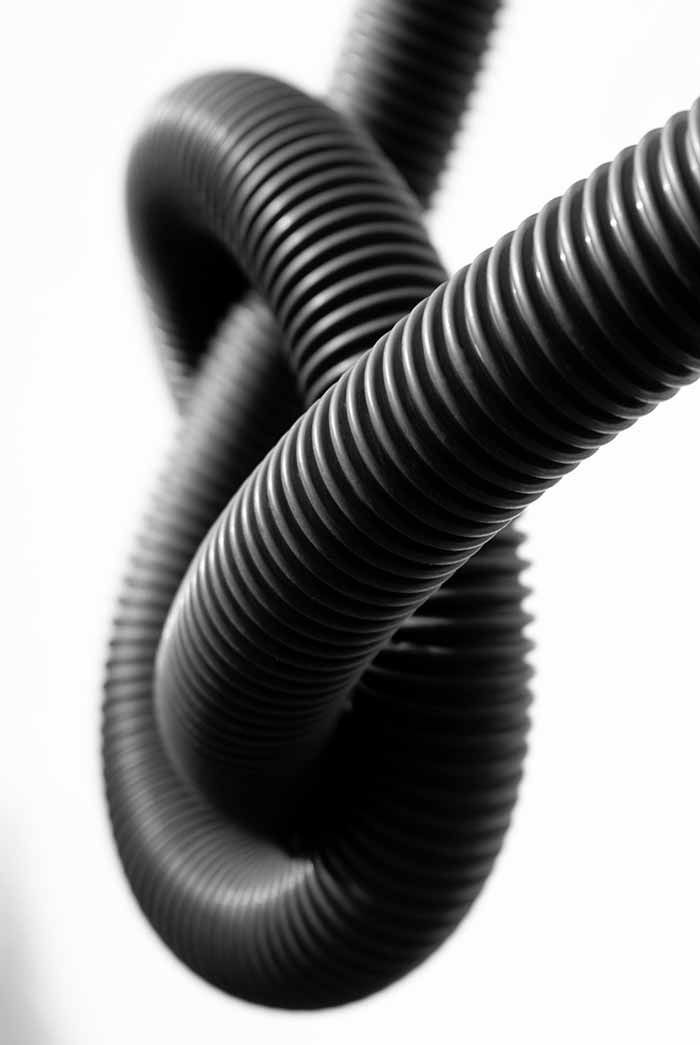 Un primer plano de una manguera negra con un nudo.