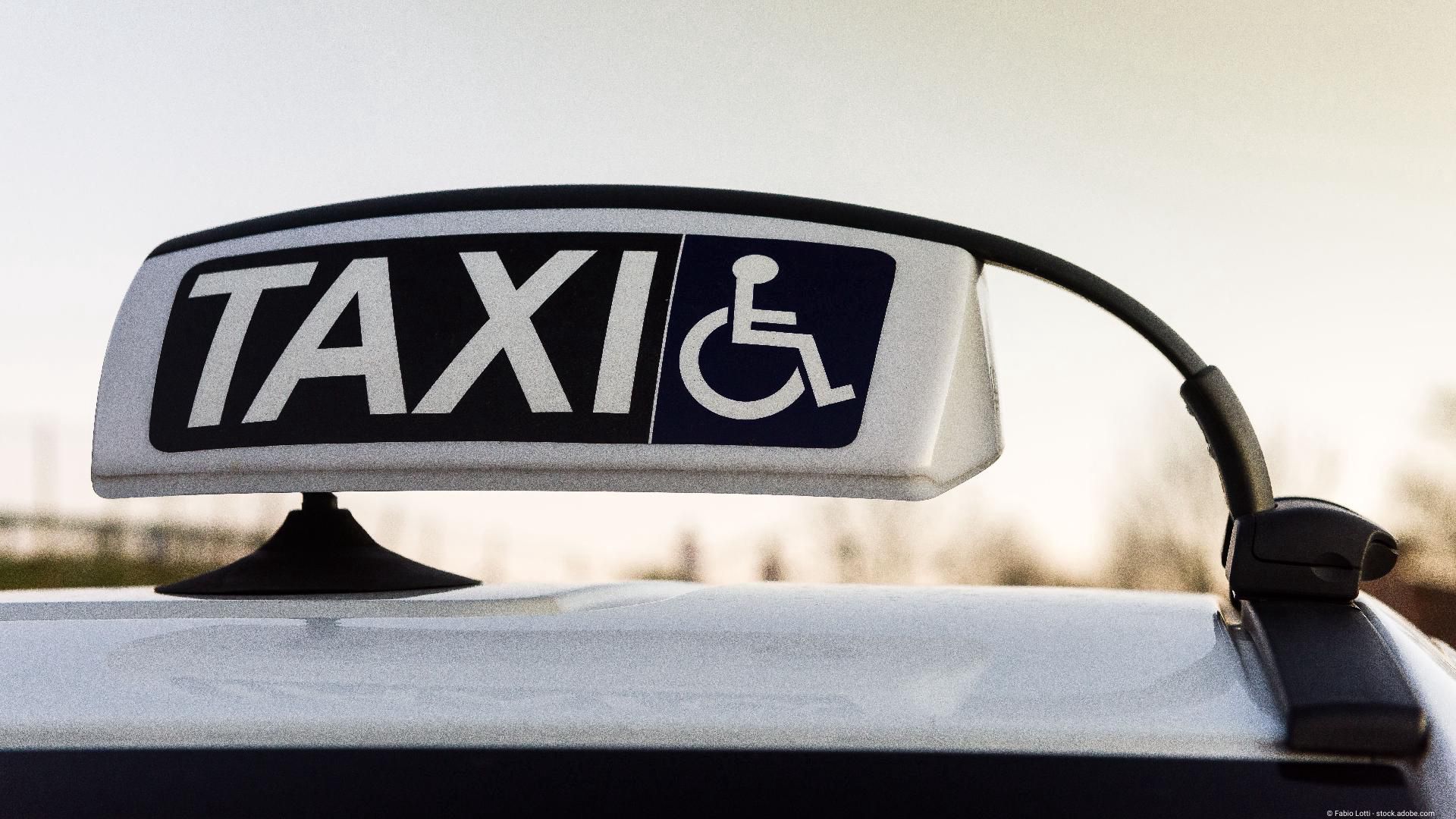 Taxi-Dachschild mit Rollstuhlsymbol, das auf barrierefreie Beförderung hinweist.