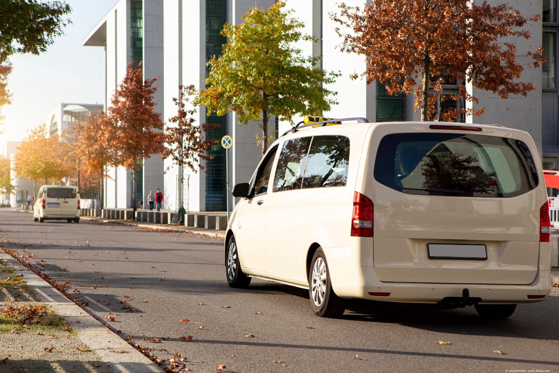 Weißer Kleinbus hält am Straßenrand in einer Stadt, bereit für eine gemeinsame komfortable Fahrt.