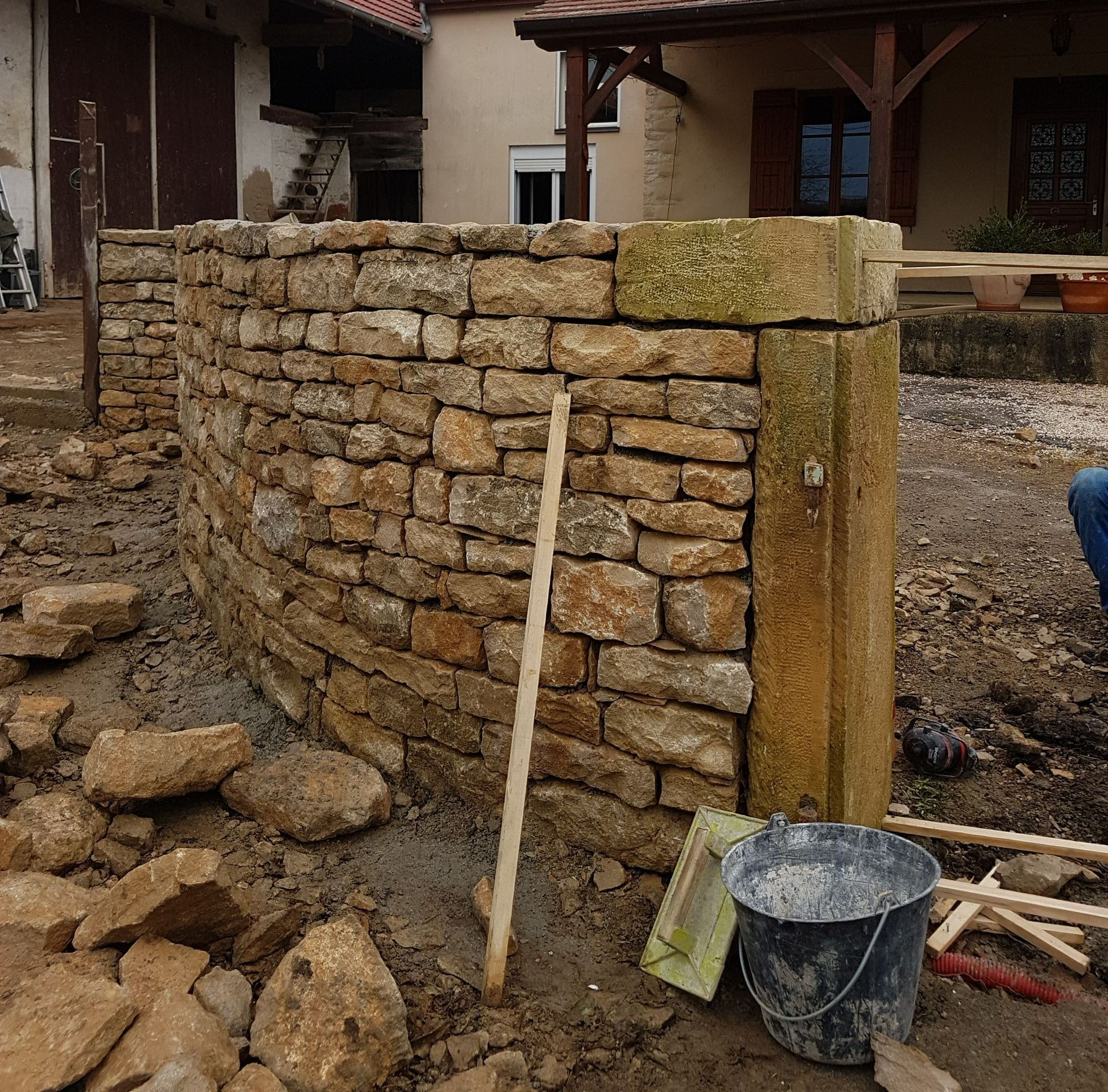 Mur en pierre finalisé par maçon