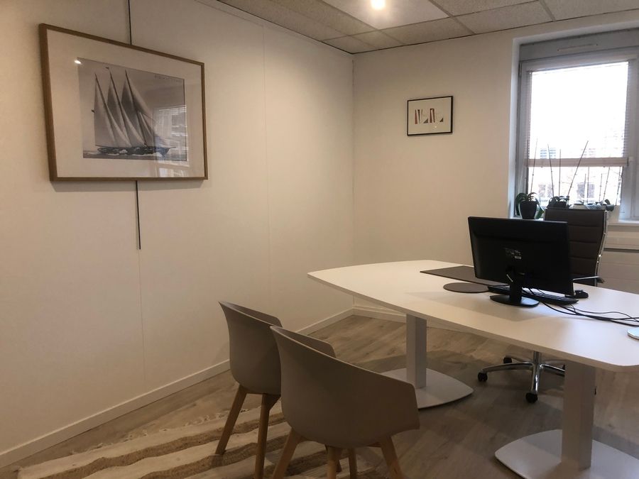 Maître Acher-Dinam devant un symbole d'arbre en métal accroché au mur