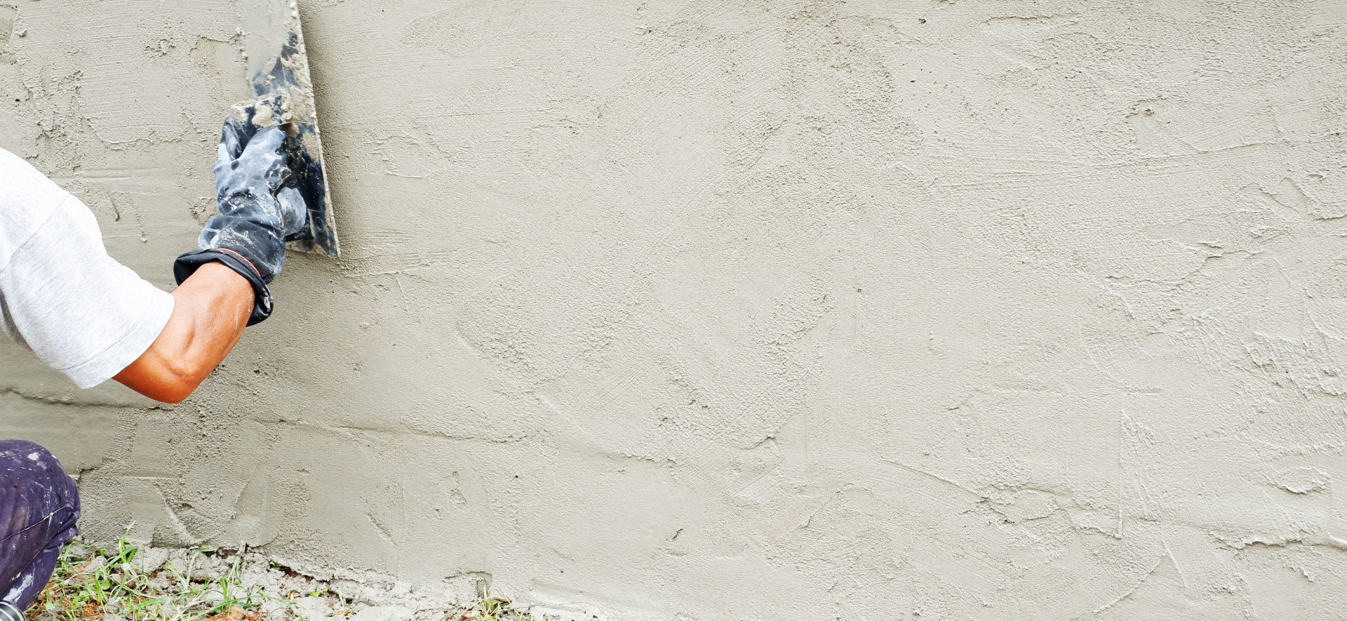 Une personne appliquant du plâtre sur un mur à l'aide d'une truelle.