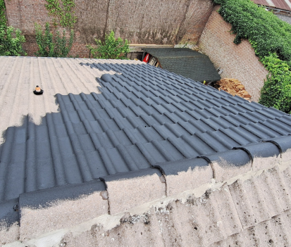 Toiture avec une section peinte en gris foncé, partiellement terminée, à l'extérieur.