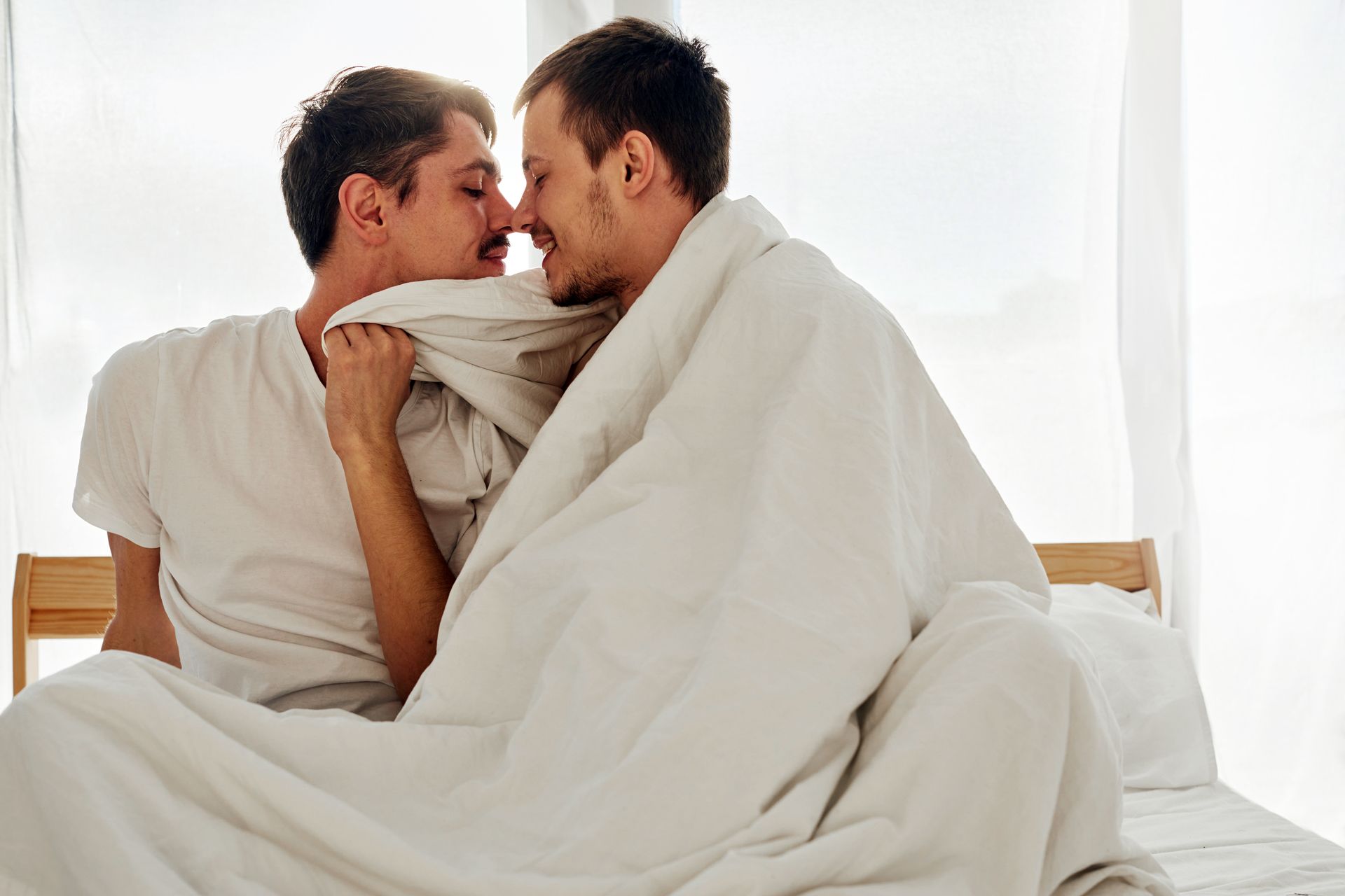 Un couple d'hommes sur le lit.