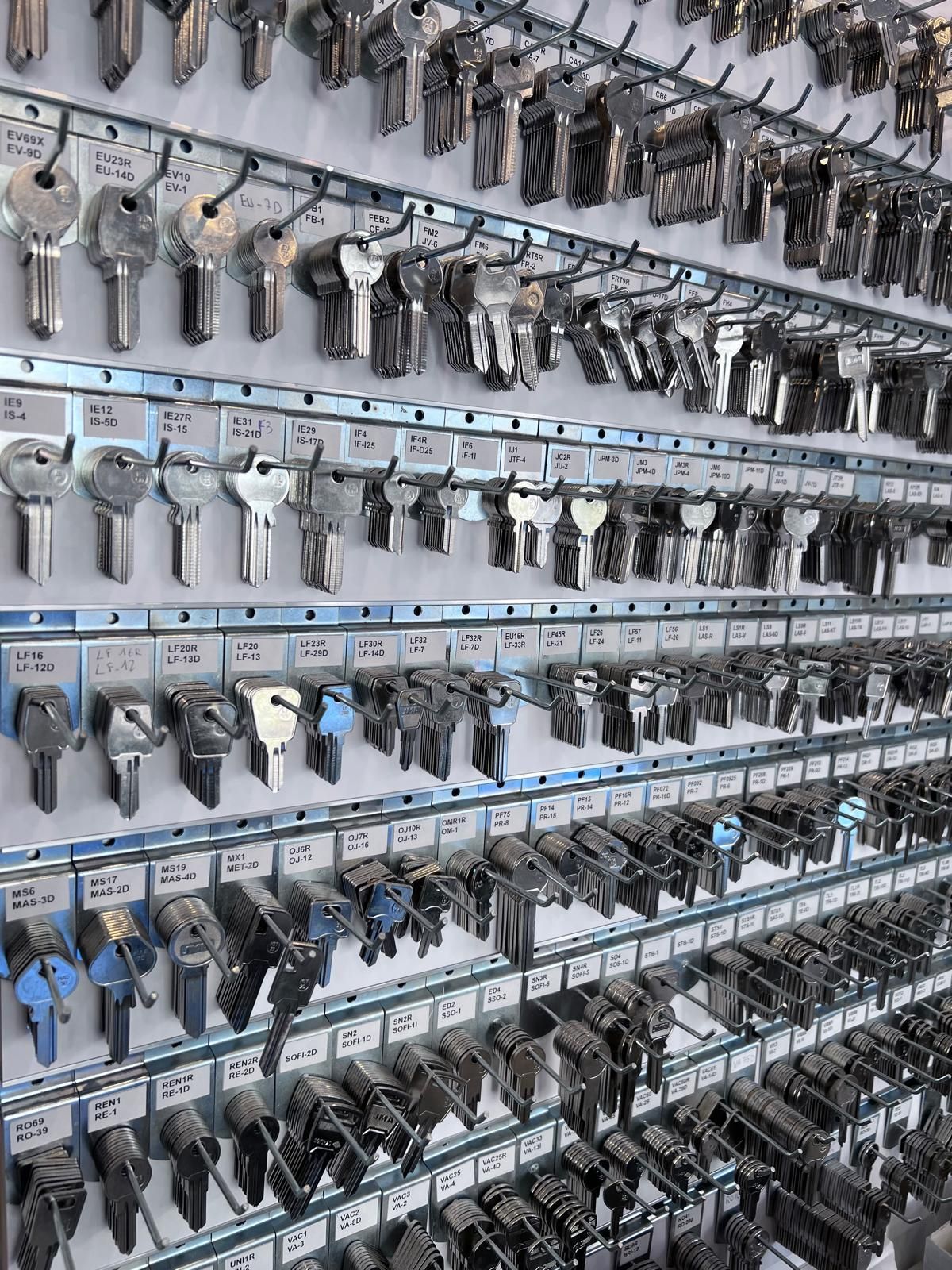 Rangées de clés accrochées sur un mur en panneau perforé.