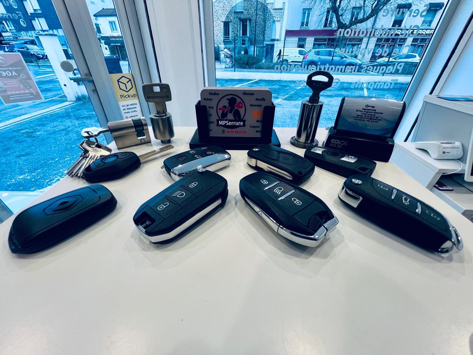 Gros plan sur la réparation d'une clé de voiture : pièces détachées sur un tapis, avec un circuit imprimé en cours de réparation.