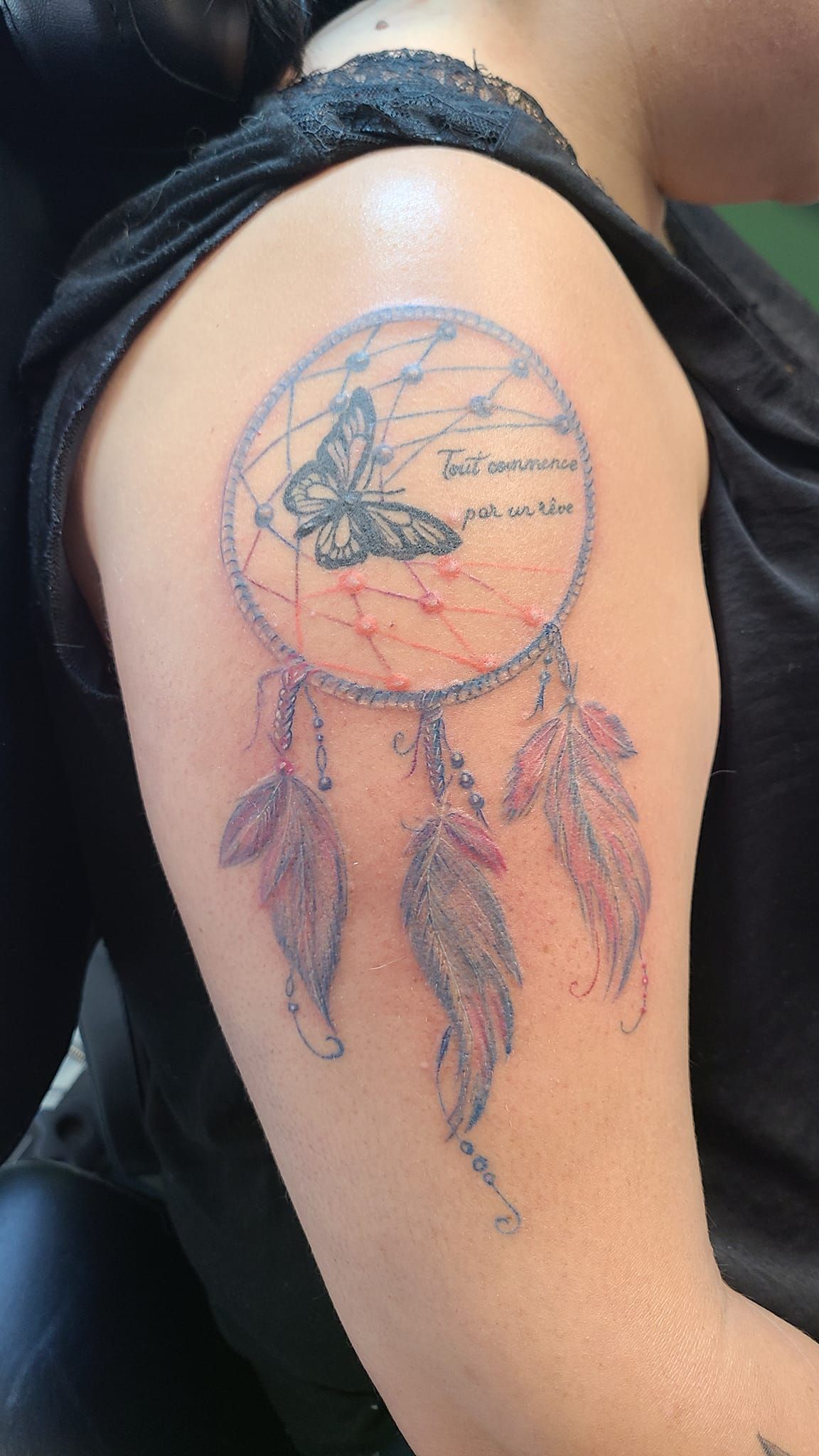 Tatouage sur haut du bras avec un attrape-rêve