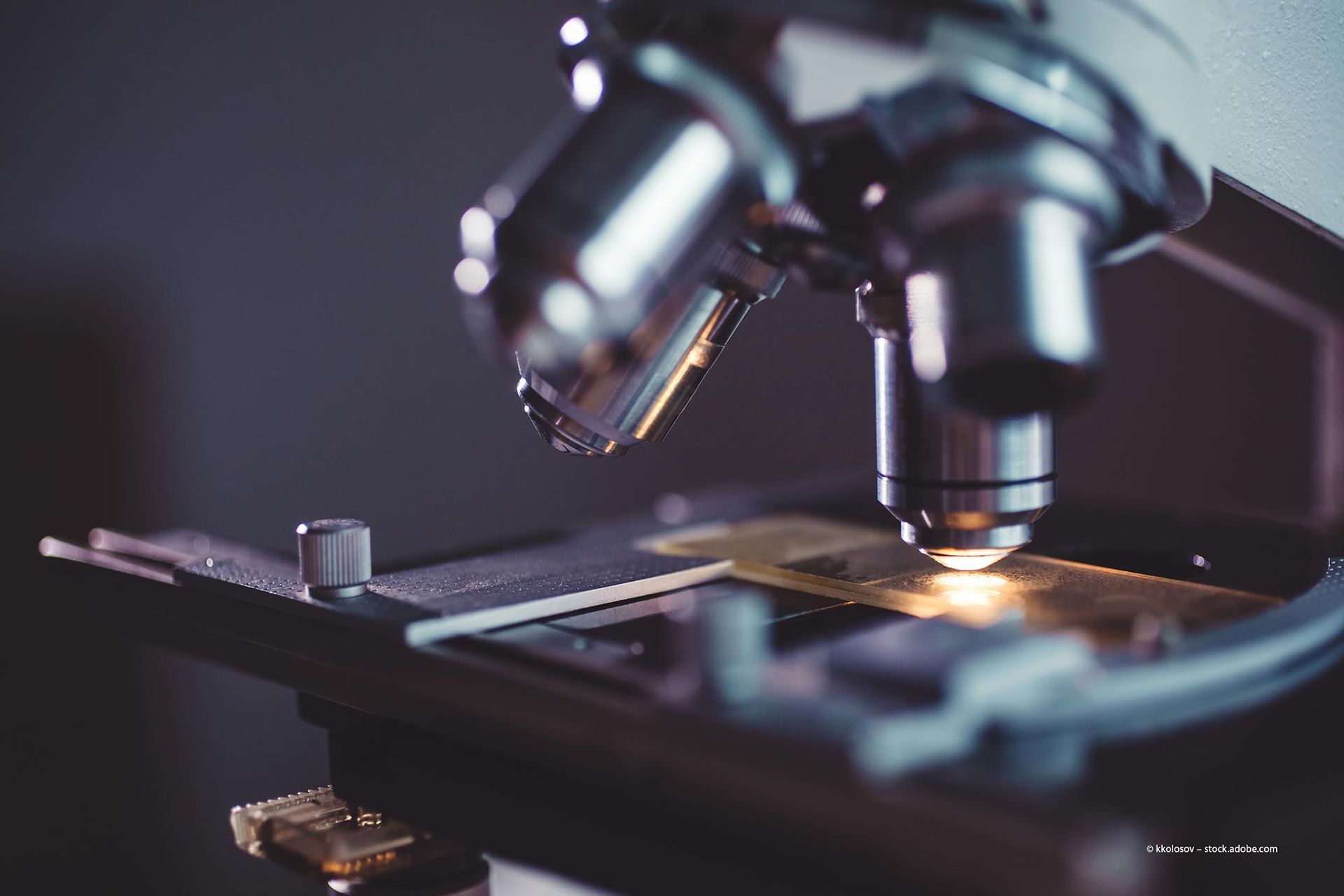 Eine Person verwendet ein Ultraschallgerät am Körper eines Patienten und trägt ein Gel auf. Der Patient ist mit einem blauen Handtuch bedeckt.