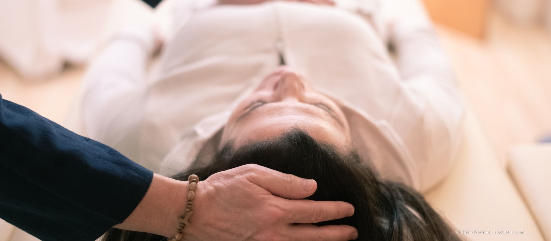 Ein medizinisches Fachpersonal misst die Kniebeugung eines Patienten mit einem Goniometer. Sie befinden sich in einer medizinischen Umgebung.