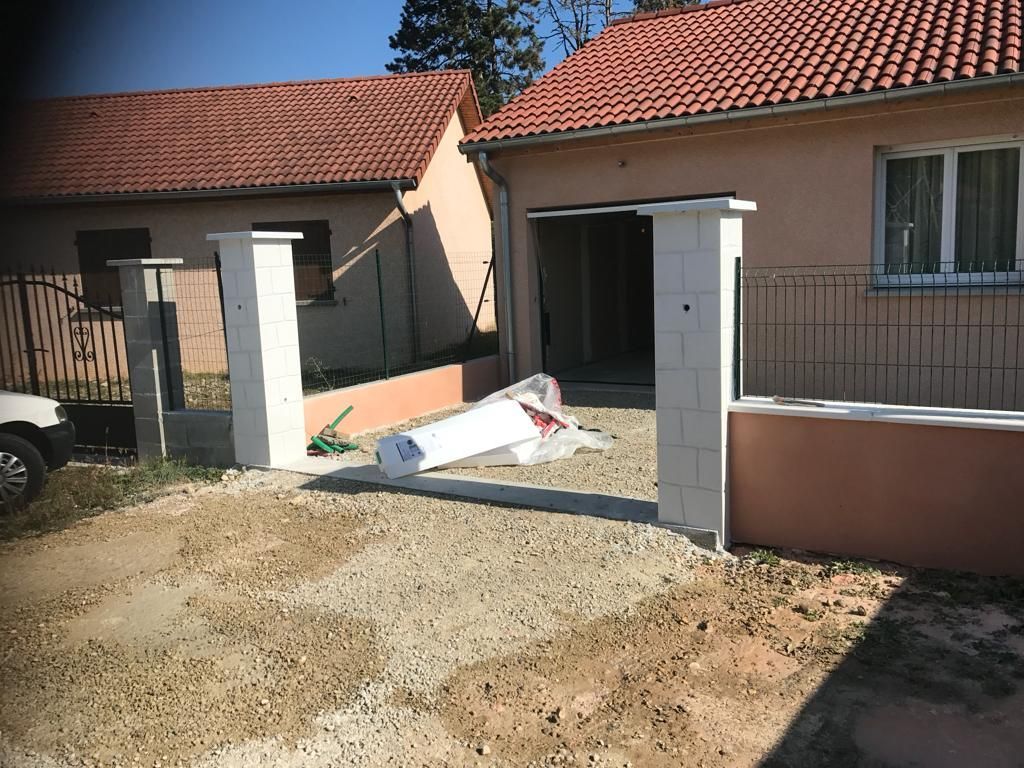 Clôture en agglo avec piliers et grillage devant un pavillon