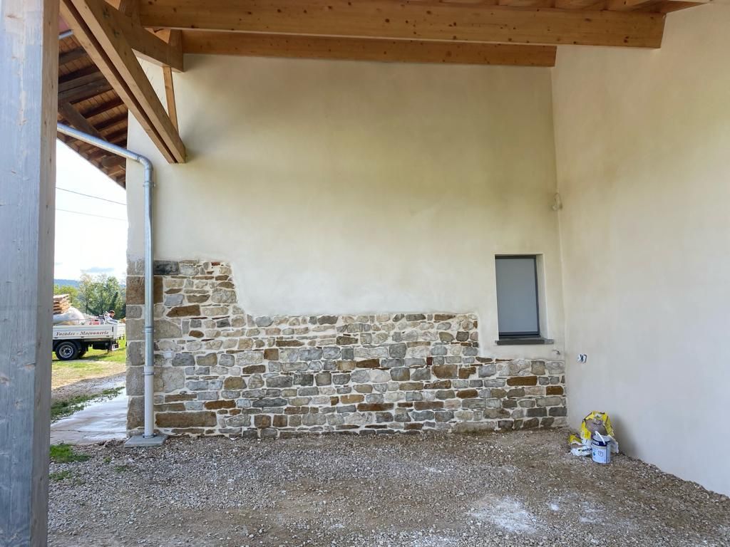 Vue latérale d'une façade en pisé, côté extension carport