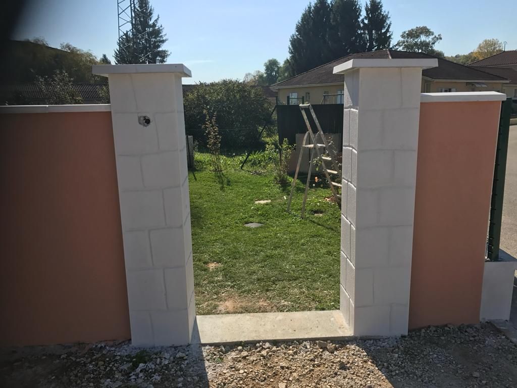 Clôture en agglo, avec enduit saumon et grillage rigide, gros plan sur les piliers avant pose de portillon
