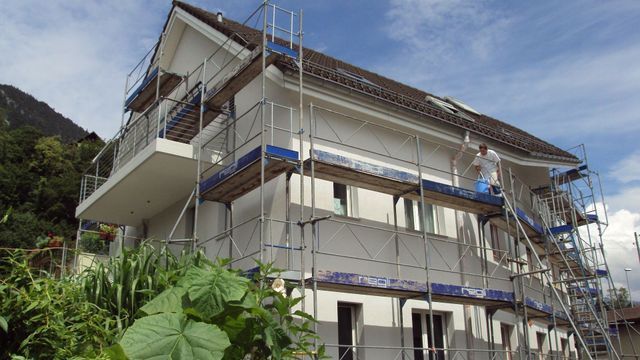 Regli Maler GmbH – Arbeiter auf einem Gerüst mit Treppen, das für Restaurierungsarbeiten an der Gebäudefassade errichtet wurde