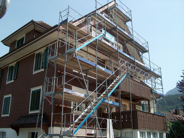 Regli Maler GmbH – Gerüst mit Treppenaufgang entlang der Außenfassade eines Gebäudes für Renovierungsarbeiten