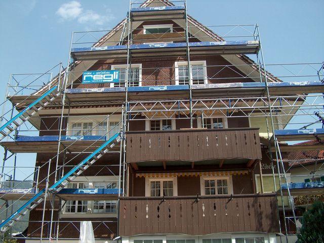 Regli Maler GmbH – eingerüstetes Gebäude mit mehreren Treppenaufgängen zur Fassadenrenovation und -reinigung