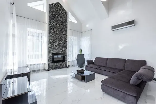 Una sala de estar con sofá, mesa de café y chimenea.