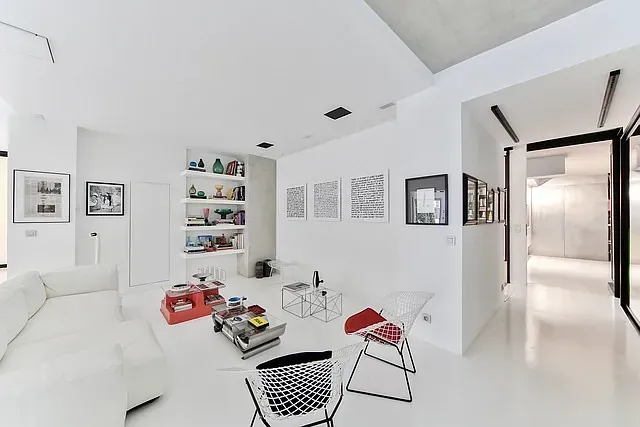 Una sala de estar con un sofá blanco y sillas.