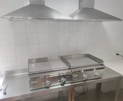Dos parrillas de acero inoxidable están colocadas encima de un mostrador de acero inoxidable.