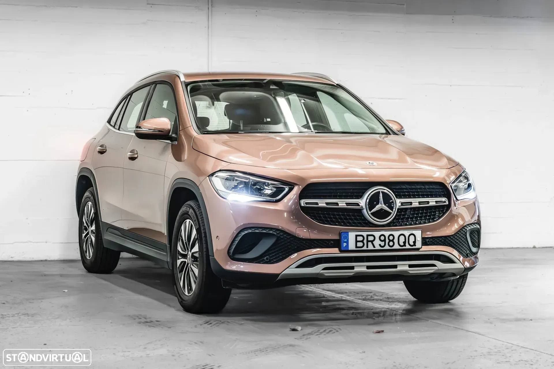 SUV Mercedes Classe GLA dourado rosa estacionado em ambiente fechado, virado para frente.