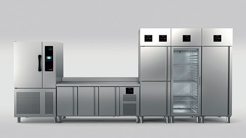 Una fila de refrigeradores y gabinetes de acero inoxidable.