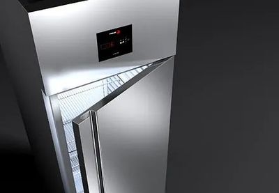 Un refrigerador de acero inoxidable con la puerta abierta sobre un fondo negro.