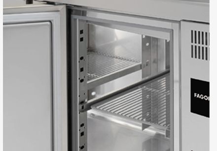 El interior de un refrigerador de acero inoxidable con la puerta abierta.