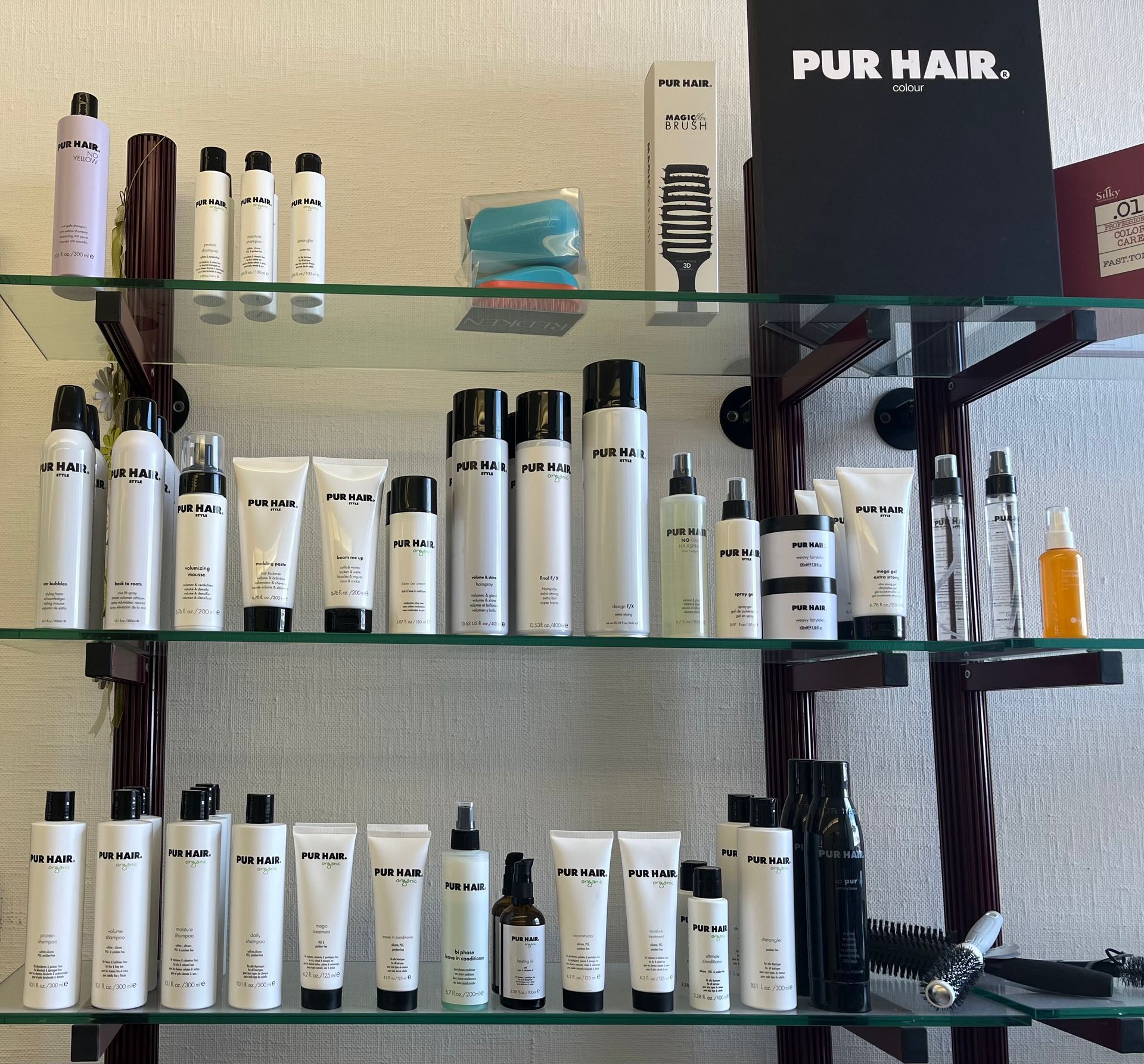 Regale mit verschiedenen weißen und schwarzen PUR-Haarpflegeprodukten.