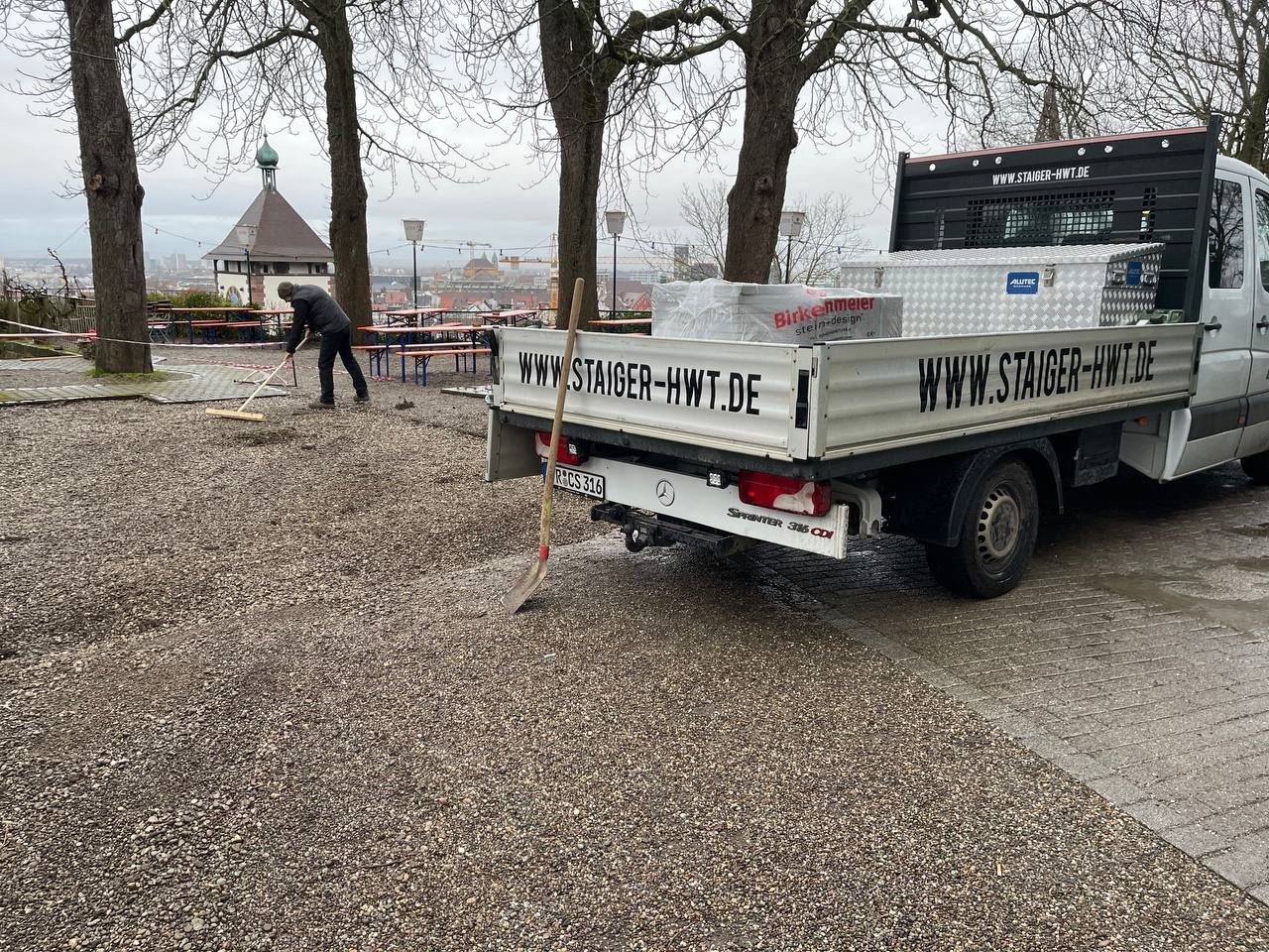Ein Mann isst Meeresfrüchte an einem Tisch im Freien, dazu Brot, eine grüne Flasche und eine Dose Erfrischungsgetränk.