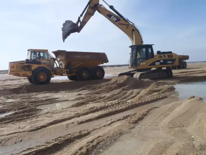 Engins de terrassement sur une plage.