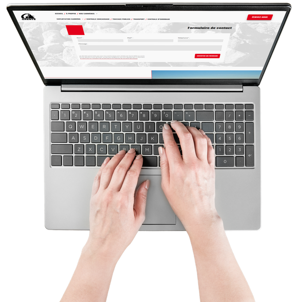 Des mains tapant sur le clavier d'un ordinateur portable vu de haut.