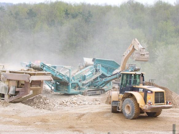 Une machine de concassage mobile sur un chantier avec engins de TP.
