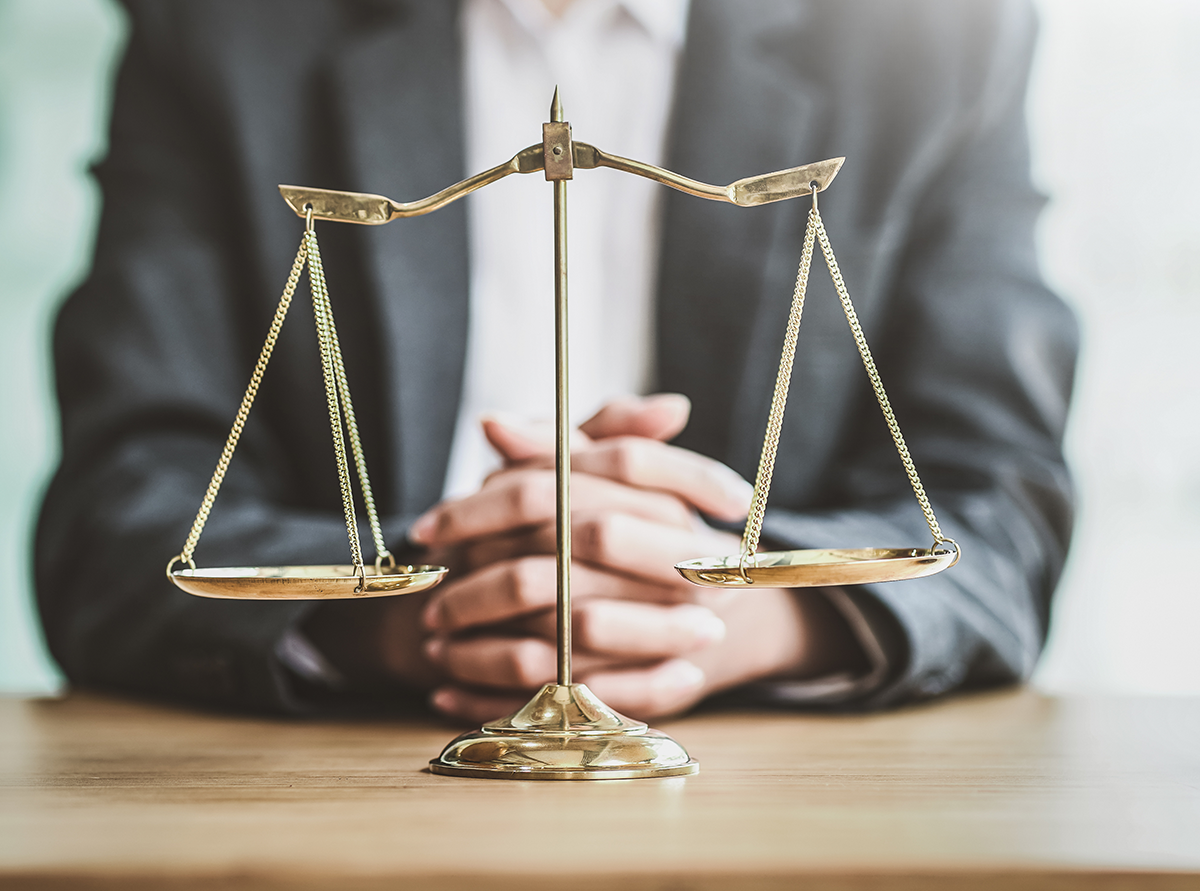 Une personne derrière une balance de la justice