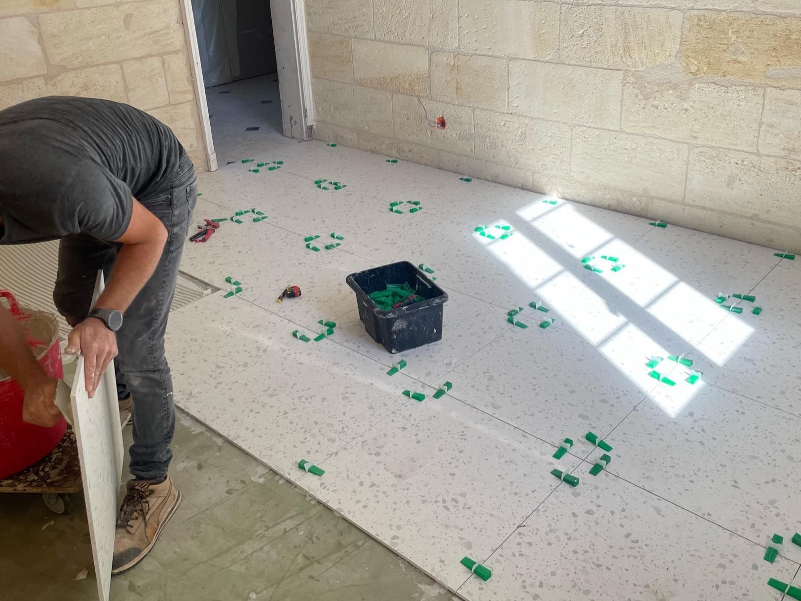 Carreleur posant des cales entre plusieurs carreaux de carrelage