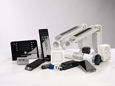 Grauer Rollladen über einem Fenster, Schnittansicht zeigt den Mechanismus.