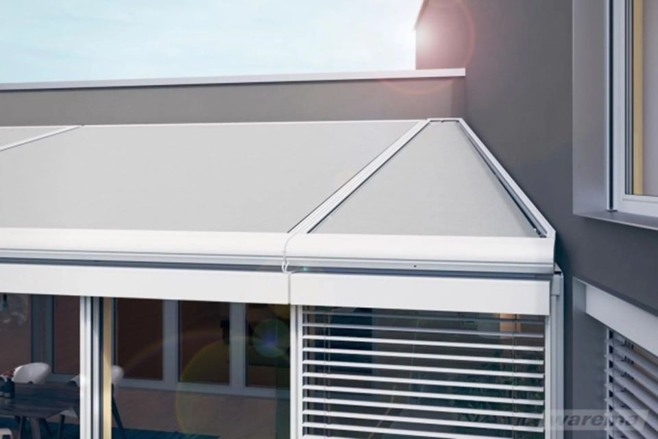 Weisses Haus mit dreieckigem Fenster über grossen Fenstern und einem kleinen Balkon.