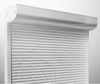 Ein weisser, mit Lamellen versehener Rollladen verdeckt teilweise eine Öffnung. Der Rollladen ist geschlossen und an einer weissen Wand montiert.