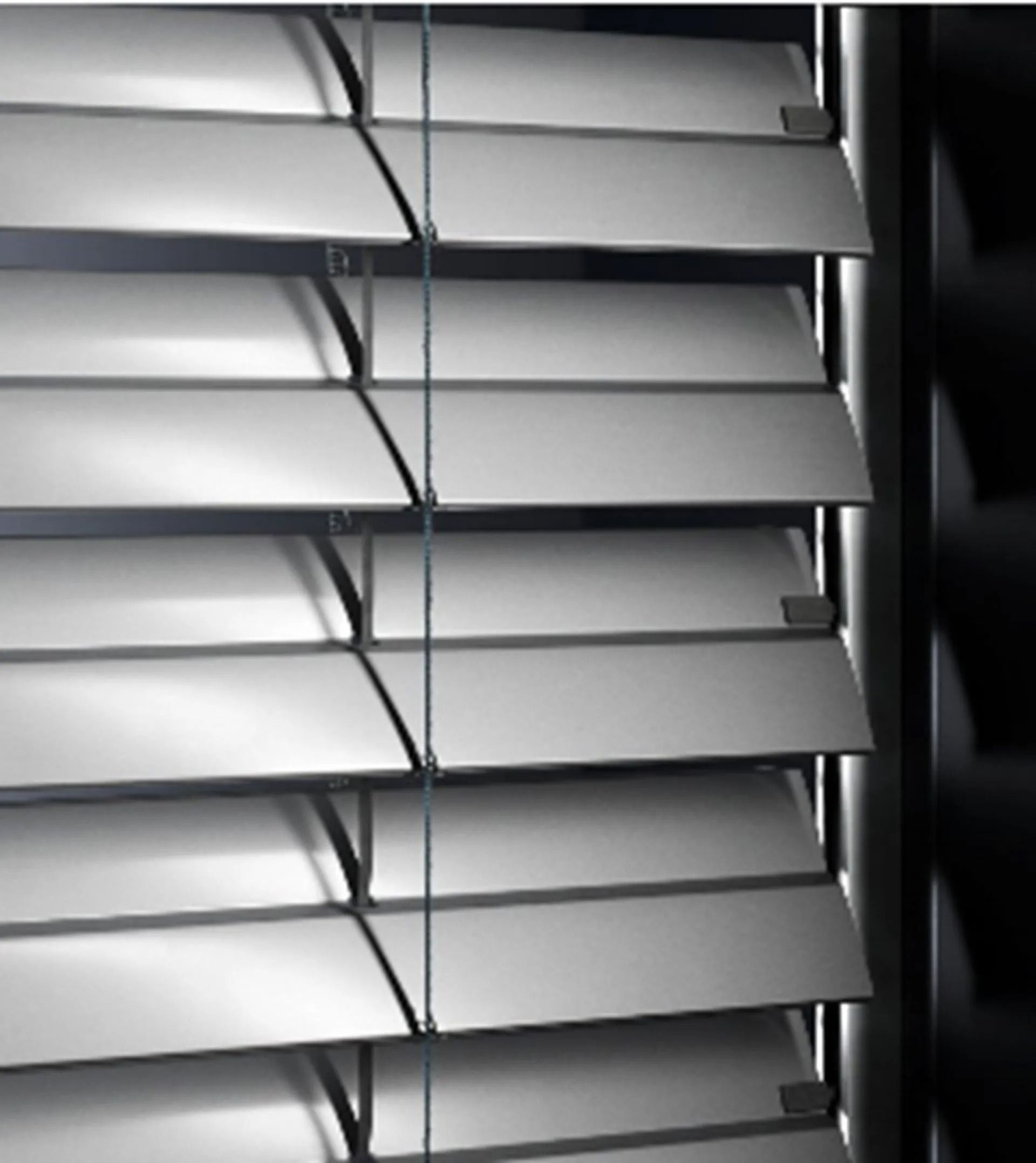 Fenster mit dunkelgrauem Rollladen und Fliegengitter, eingelassen in eine weisse Aussenwand mit grauer Fensterbank.