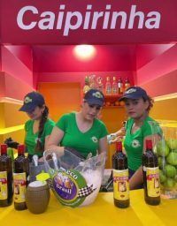 Un grupo de mujeres de pie detrás de un mostrador con botellas de alcohol.
