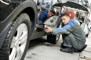 Prüfer kontrolliert Schaden an PKW