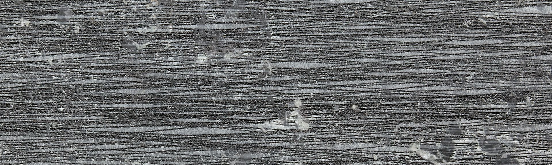 Dunkler Speckstein Tulikivi Grafia mit linearer Struktur für modernen Kaminofen